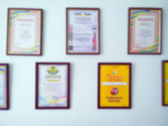 blurred certificates and diplomas on wall