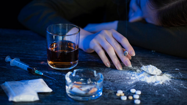 young female surrounded by drugs and alcohol