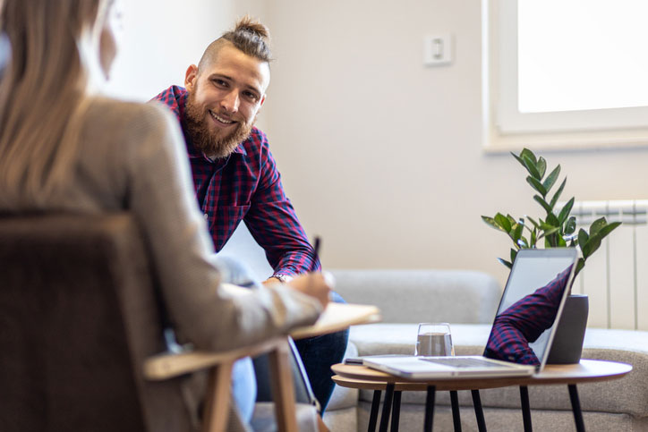 female counselor talking with young man about addiction