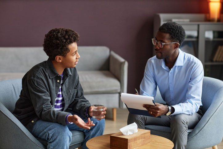 young man talking with a youth and teen counselor