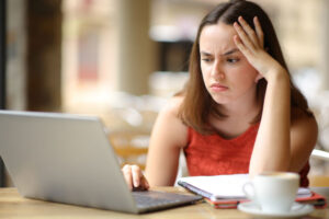 frustrated young woman learning in cafe