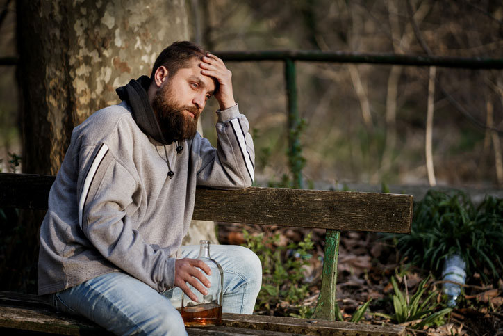 man on bench dealing with alcohol addiction