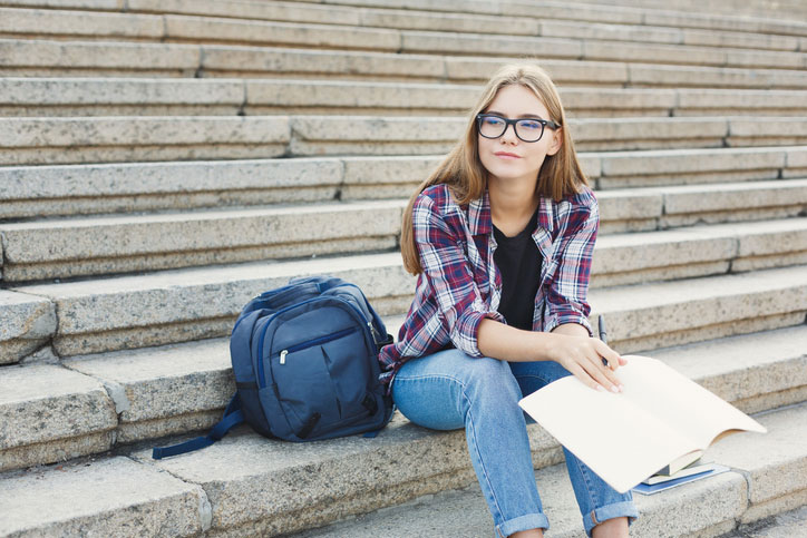 female student sitting on steps outside class