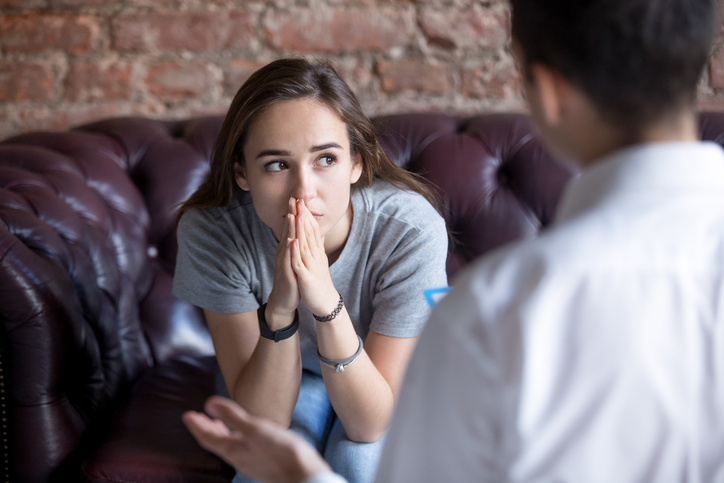 Unhappy young girl at receiving help from a counselor