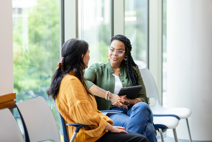 Young adult woman shares her problems with the young adult female counselor.