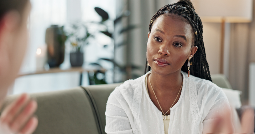 Psychology, mental health and empathy with a black woman therapist talking to a patient in her office.