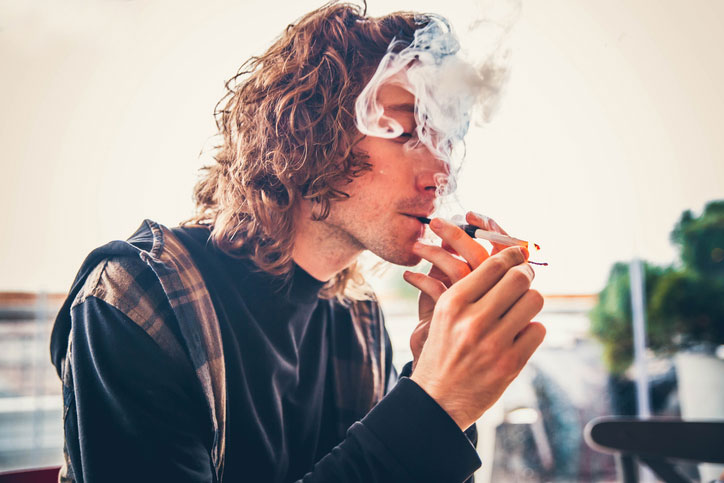 Man lighting cigarette illustrating nicotine addiction and substance use disorder