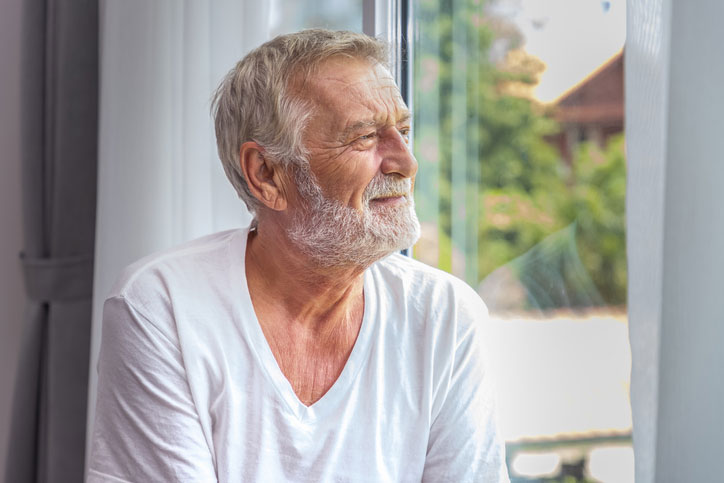 elderly man looking out the window