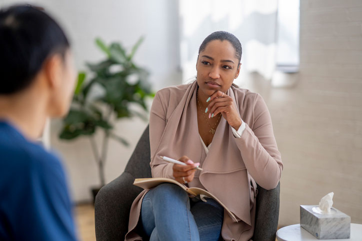 young man in therapy session with female counselor