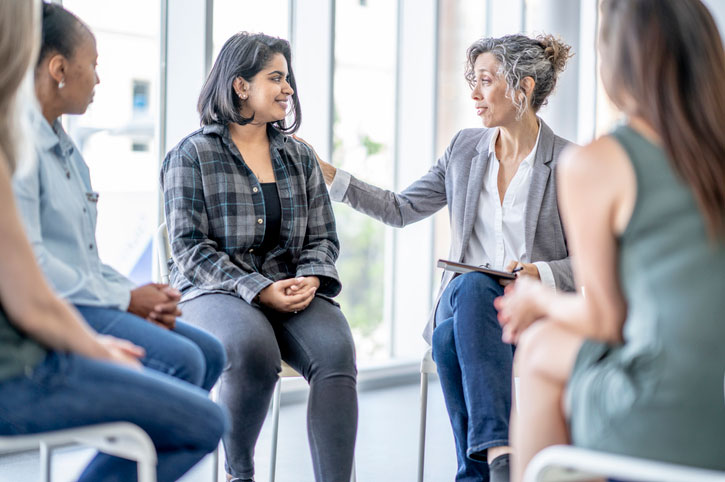 certified peer support specialist facilitating group therapy session in substance abuse recovery program