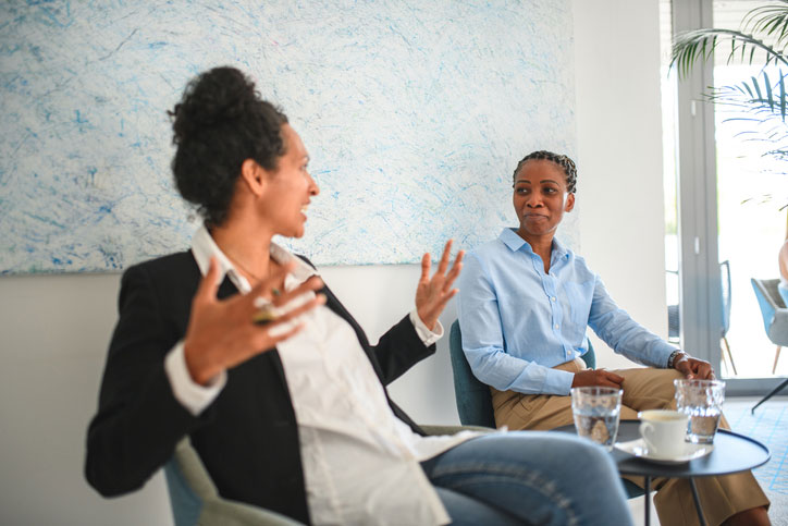 hispanic female talking with black female colleague