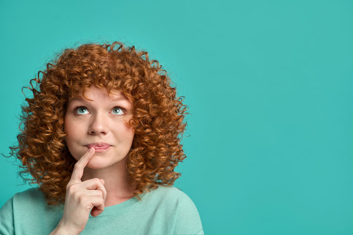 woman with curly hair thinking about something