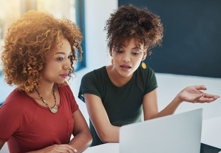 two woman working hard together