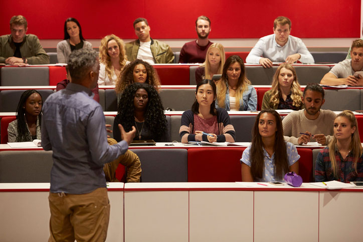 man presenting to group in lecture hall