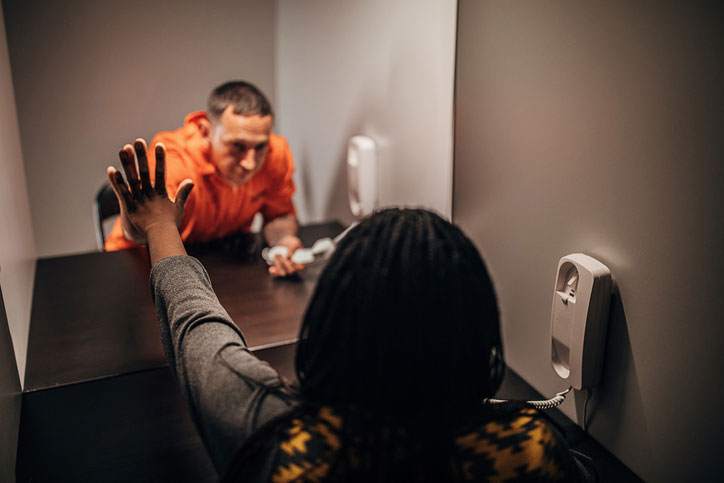 male prisoner talking with wife through glass