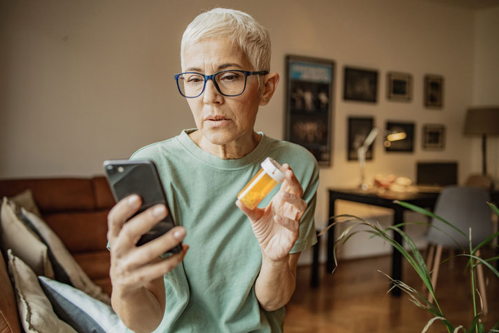 senior woman looking for prescription information on her bottle