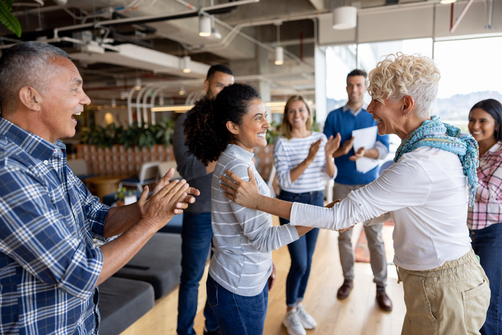 Woman getting congradulated at work