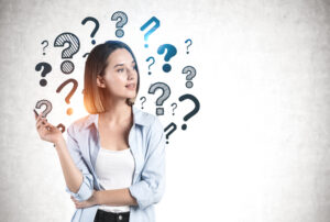 Young woman contemplating education choices with question marks surrounding her, representing the decision between associates vs bachelor's degree in substance abuse counseling